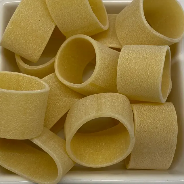 A close up shot of Calamarata in a square white glass bowl