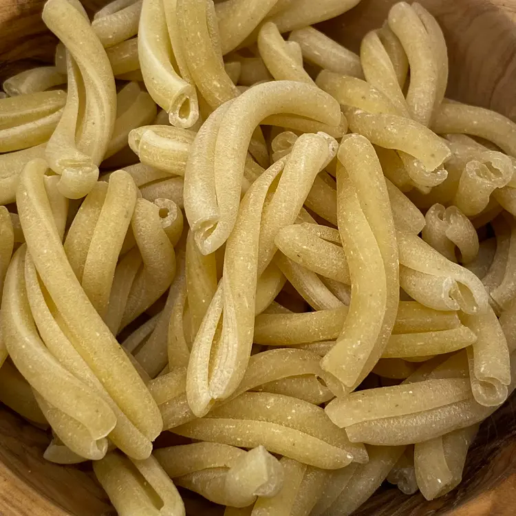 A close up shot of Casarecce in a round wooden bowl
