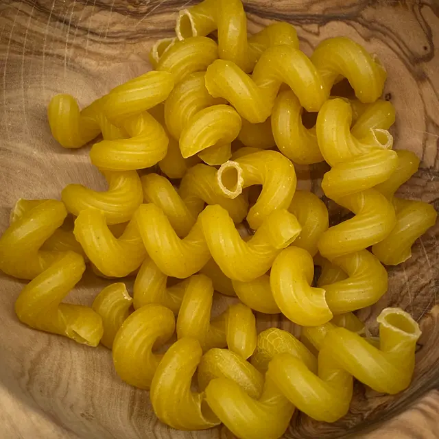 A close up shot of Cavatappi in a round wooden bowl