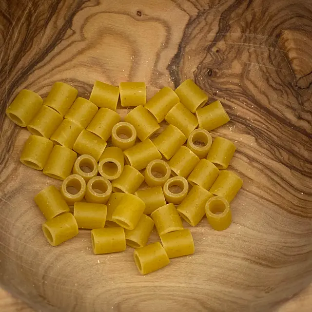 A close up shot of Ditalini in a round wooden bowl