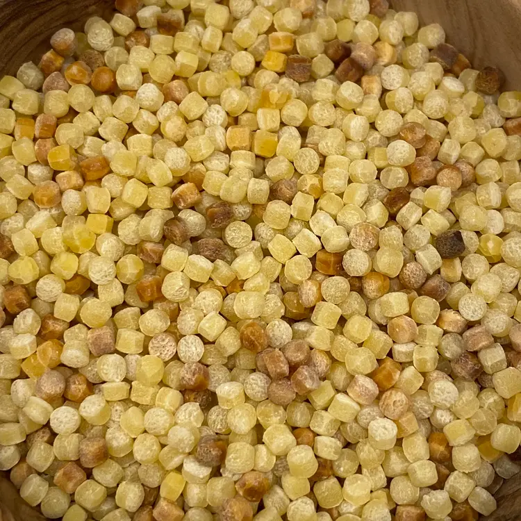 A close up shot of Fregola in a round wooden bowl