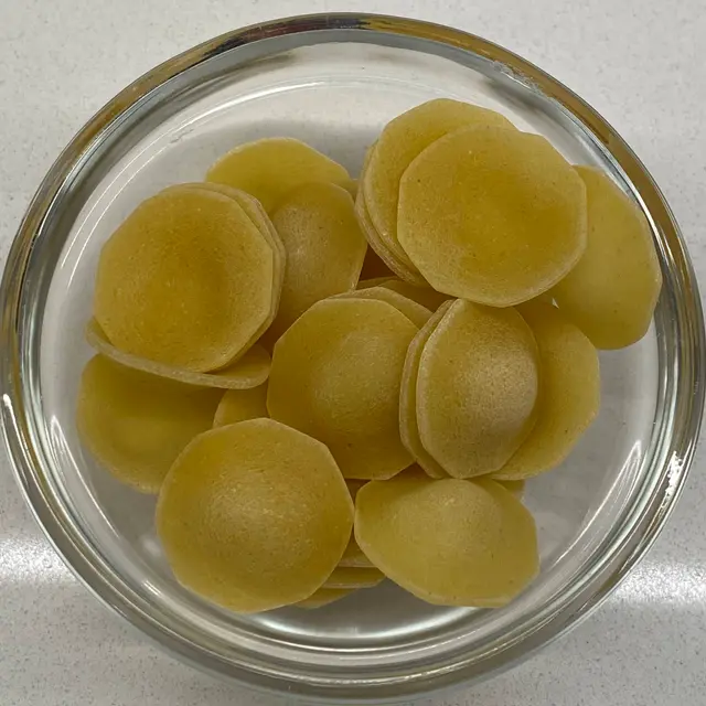 A close up shot of Orecchiette in a small round white glass bowl