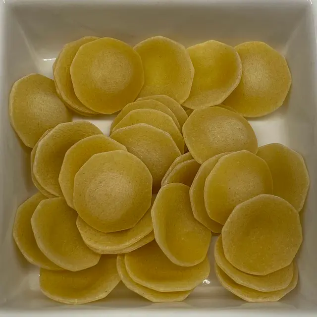 A close up shot of Orecchiette in a square white glass bowl