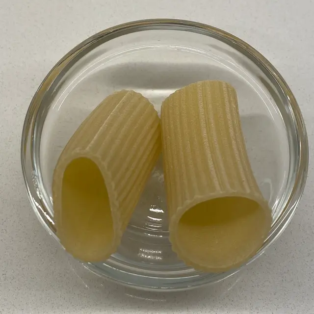 A close up shot of Paccheri in a small round white glass bowl