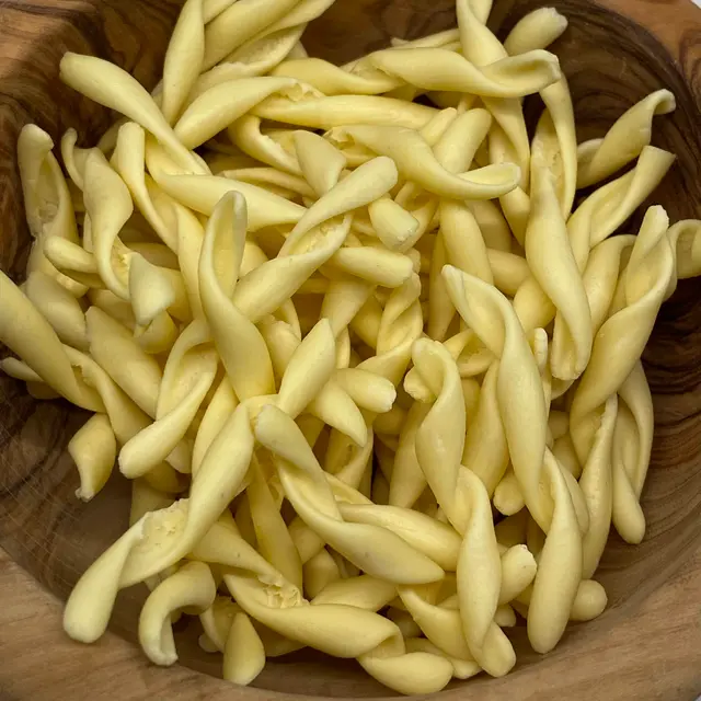 A close up shot of Strozzapreti in a round wooden bowl